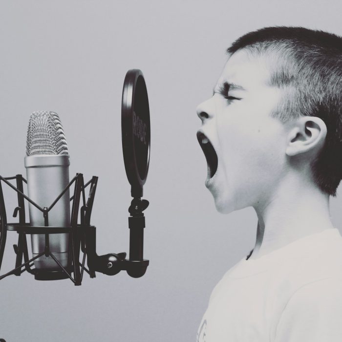 boy singing on microphone with pop filter