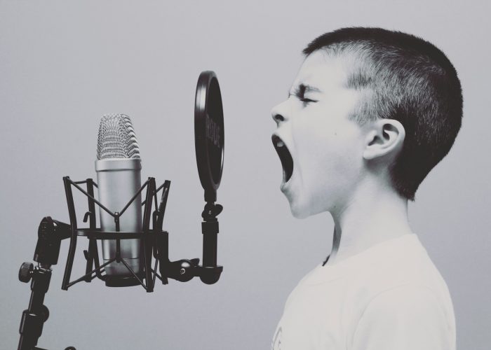 boy singing on microphone with pop filter