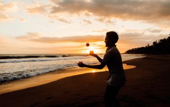 man in white shirt standing on beach during sunset