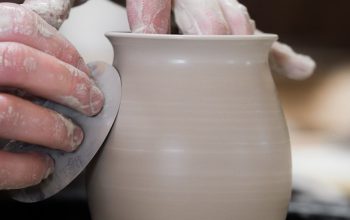 person holding white clay pot